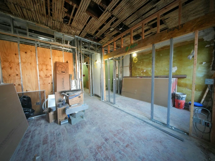 Interior room under construction with exposed drywall and ceiling.