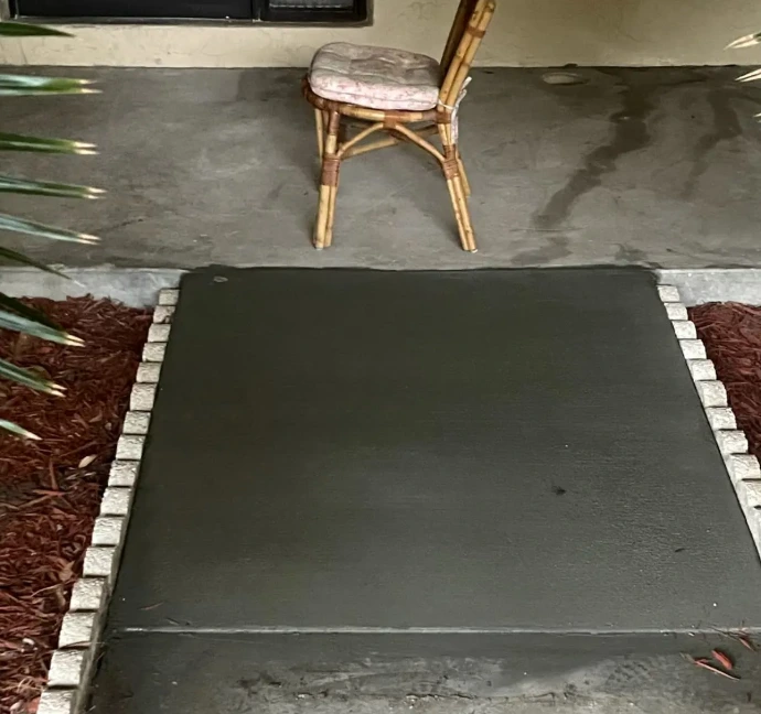 newly poured concrete pad walkway featuring a dark gray or charcoal finish