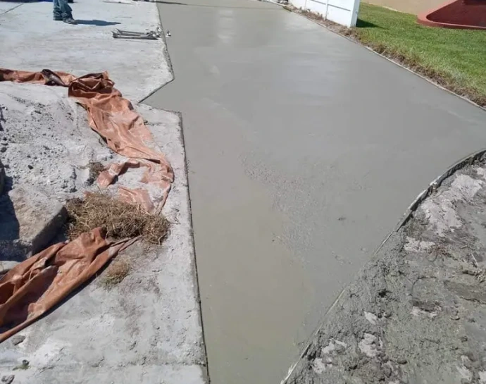 a concrete driveway undergoing a transformation, featuring techniques to enhance its appearance and functionality