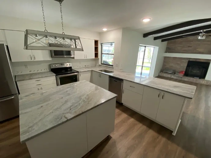 modern white shaker kitchen featuring Stream White granite countertops and a central island