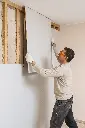Drywall replacement – worker installing new sheet onto exposed studs.webp