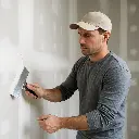 Drywall finishing – worker applying joint compound to seams.webp